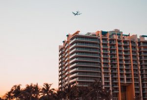 Airplane Flying By A Tall Building