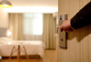 A Person Opening the Door of a Hotel Room
