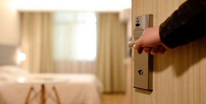 A Person Opening the Door of a Hotel Room